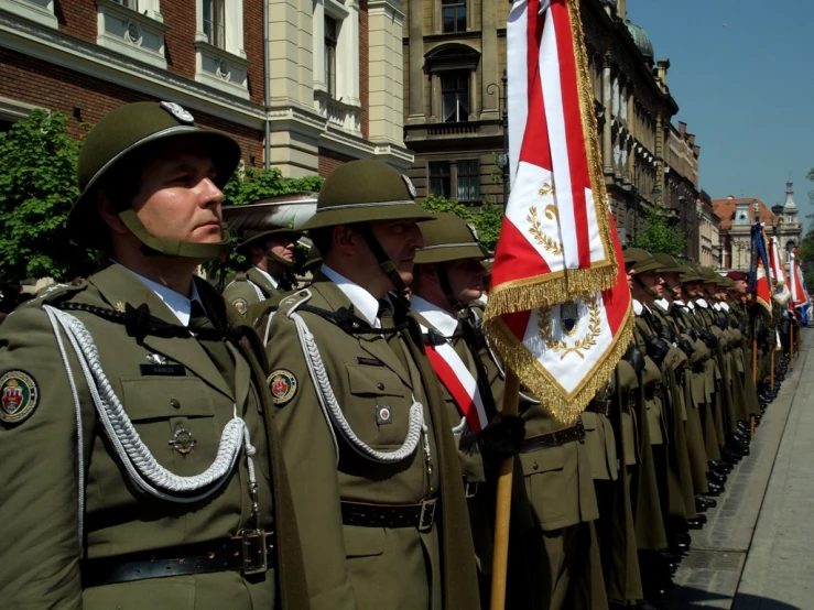 a bunch of men in army uniforms stand on the street