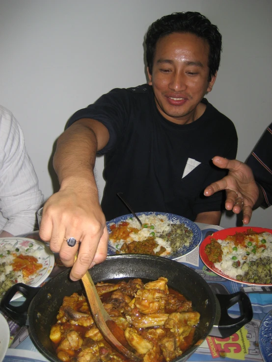 a man is serving food from a large pan