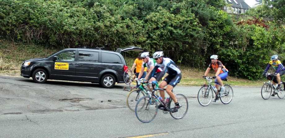 a group of bikers riding on the side of the road