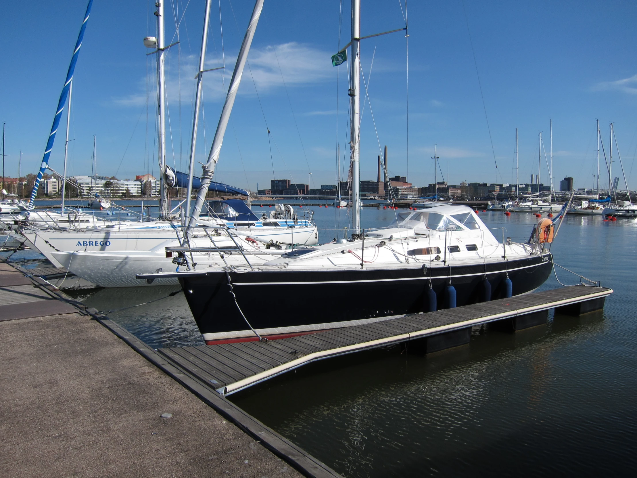 three large boats sitting in a harbor with other sailboats in the water