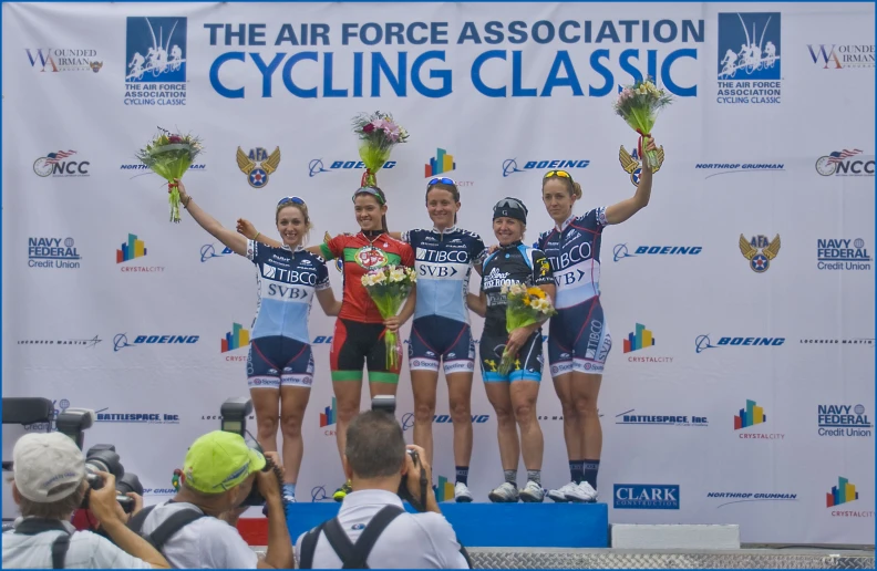 three women standing on top of a podium with two on the podium