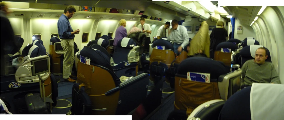 an airplane filled with people and some are standing in rows