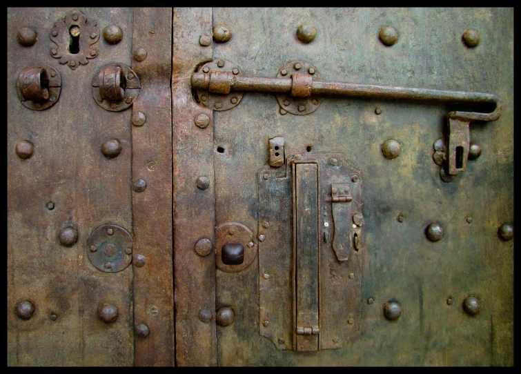 the old, rusty door is closed by metal fittings