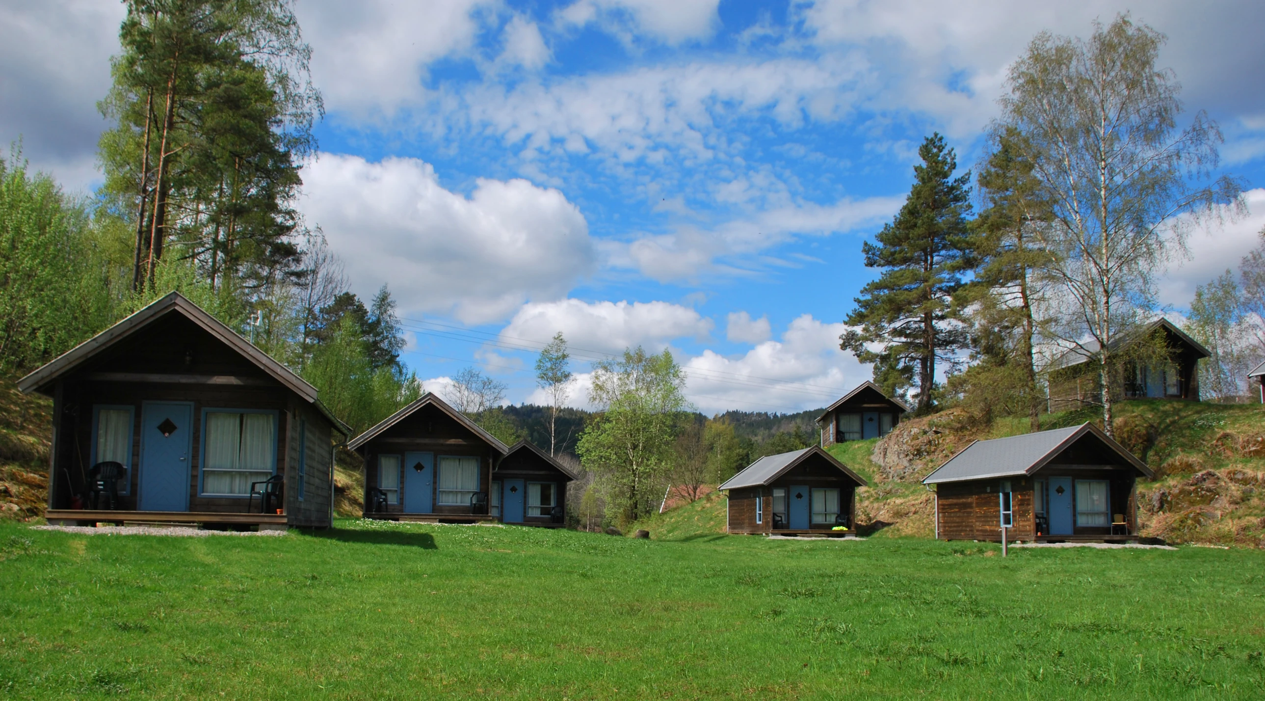 small wooden cabin type buildings in a green field