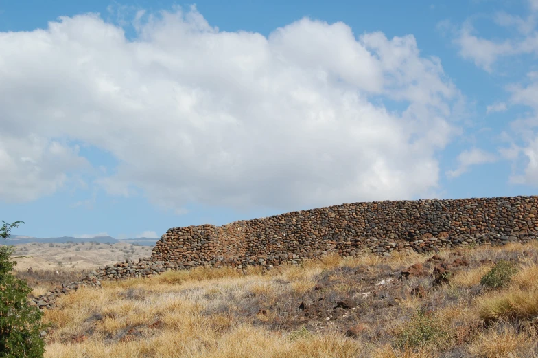 a tall hill with a rock cliff next to it