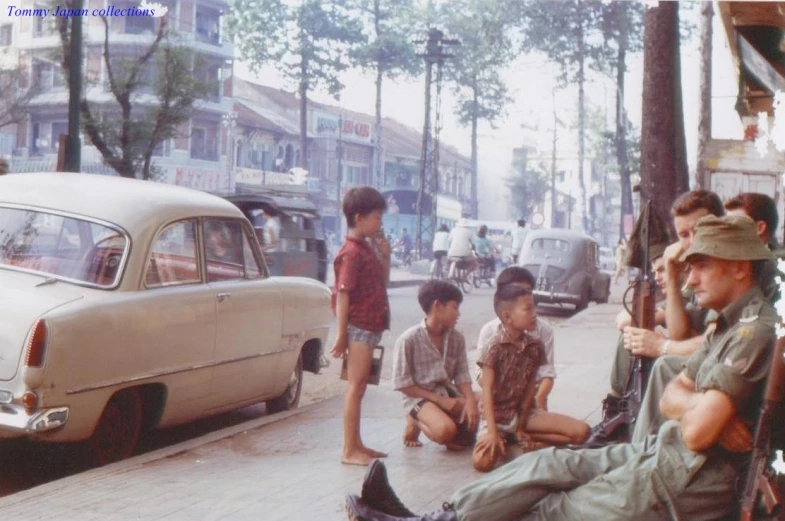 an old time picture shows s sitting on the curb and looking at soing