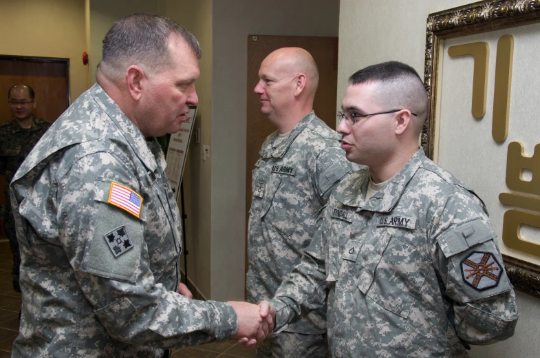 two men in military fatigues shaking hands