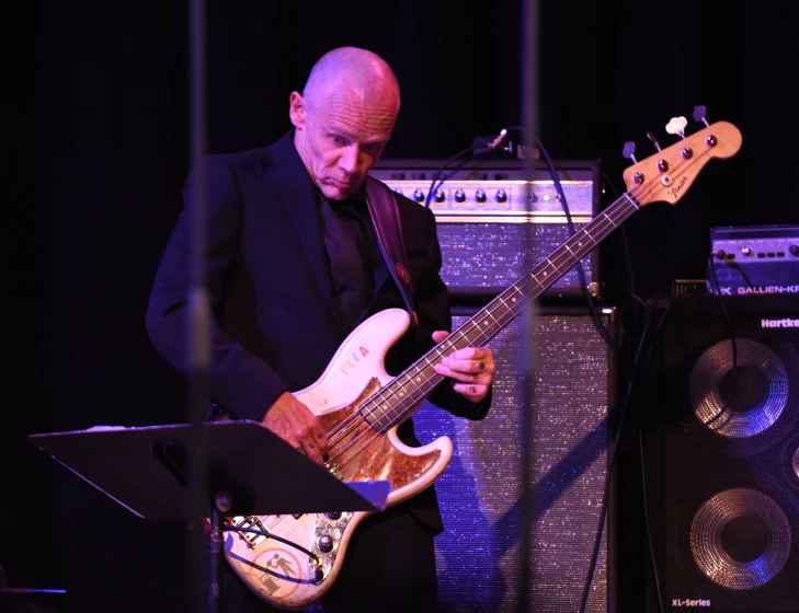 a man that is holding an electric guitar