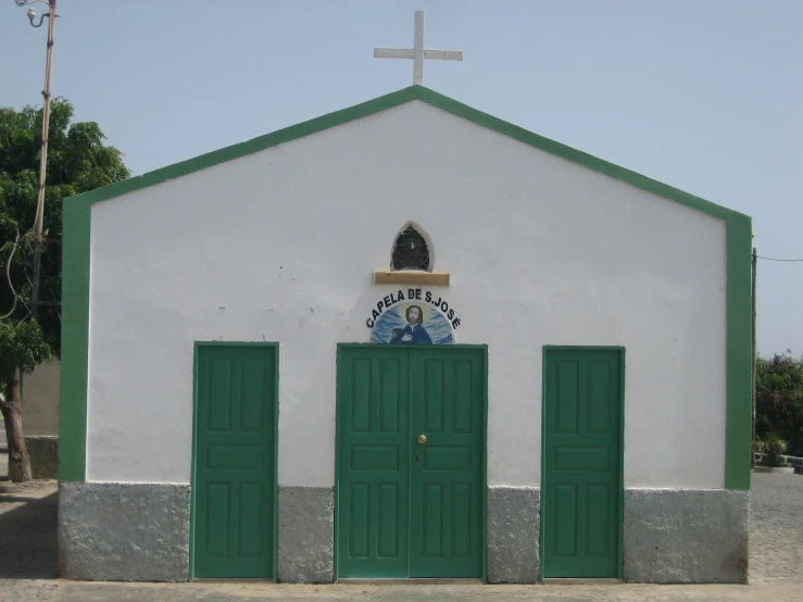 a large white building with green doors and an emblem on the front