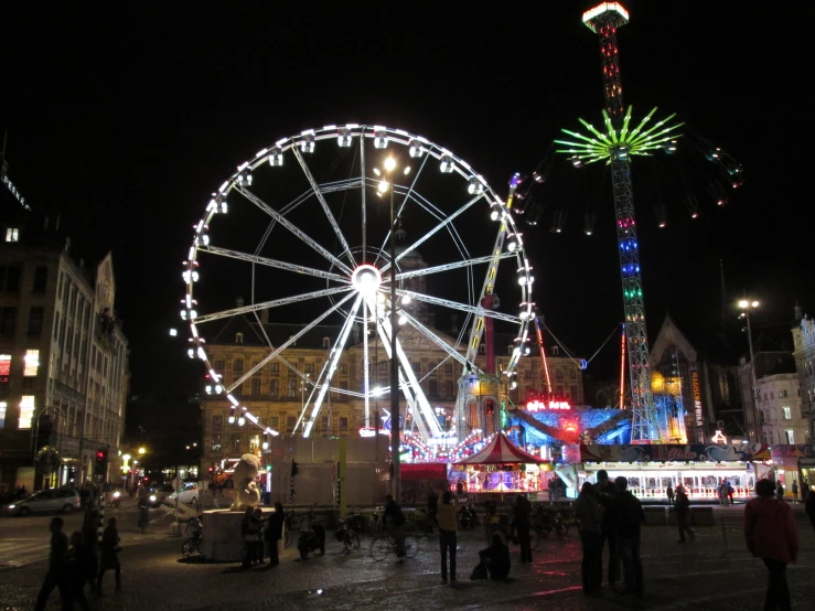 an elaborate light display stands in the night, surrounded by buildings