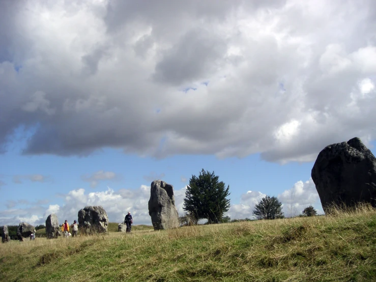 several people walking around standing near large rocks