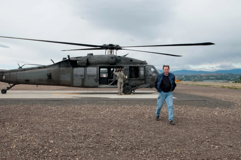 a man standing next to a helicopter that is on the ground