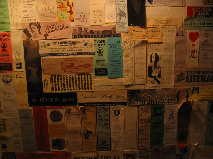 a wall full of many different papers, and a paper bag