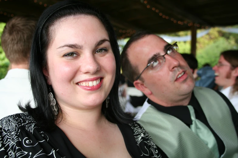 man and woman posing for a picture in a park