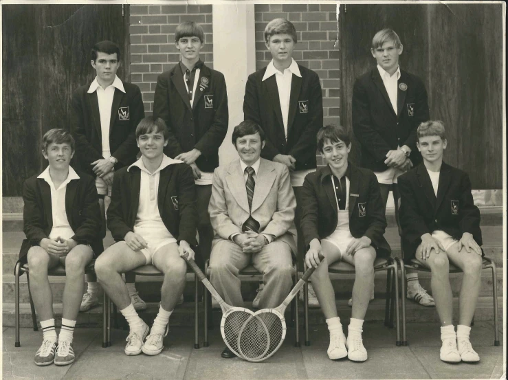 several boys with tennis rackets are posing for a po