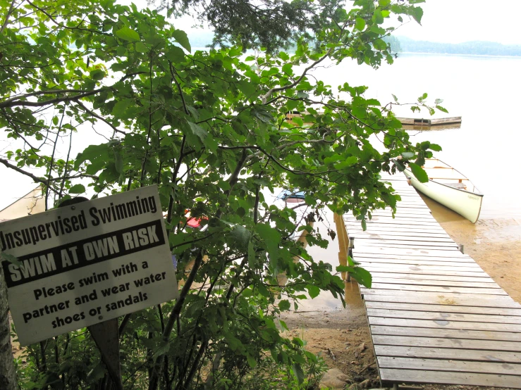 a wooden dock next to the water with two boats