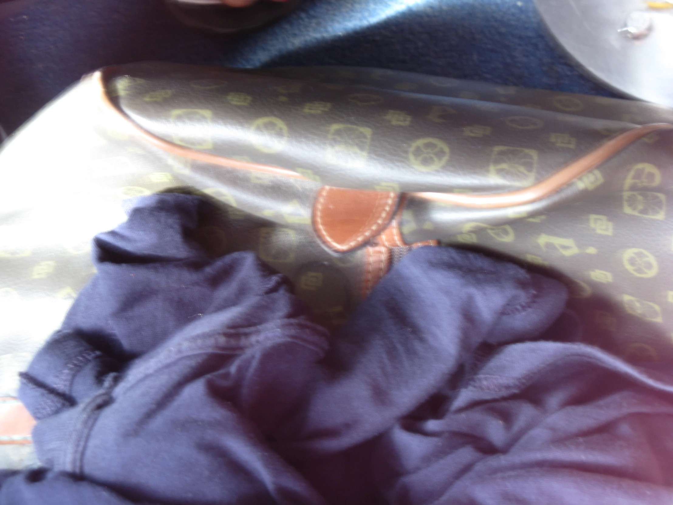 an unzipped purse on top of clothes