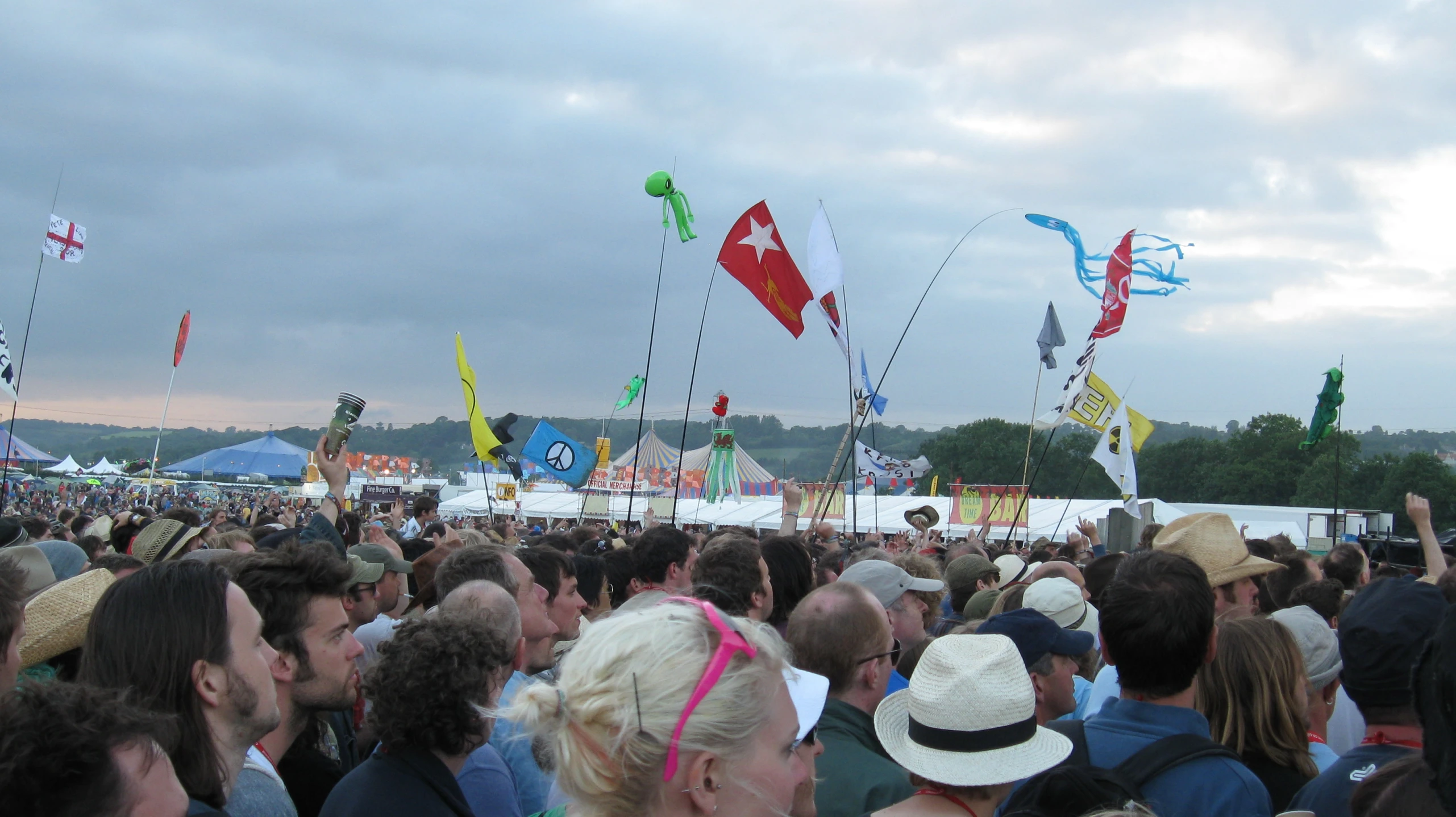 several people at an outdoor festival flying kites