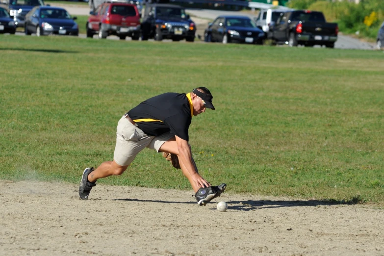 a baseball player reaching over the base to catch a ball