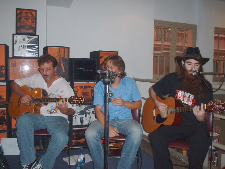 three men are playing the guitar on stage