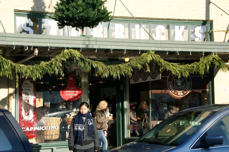 the shop in which the car is parked has a couple standing outside