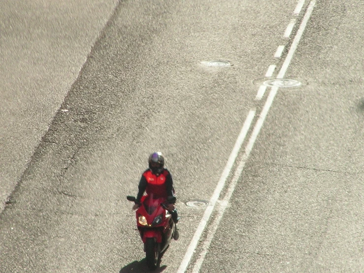 a person in a red outfit riding a motor cycle