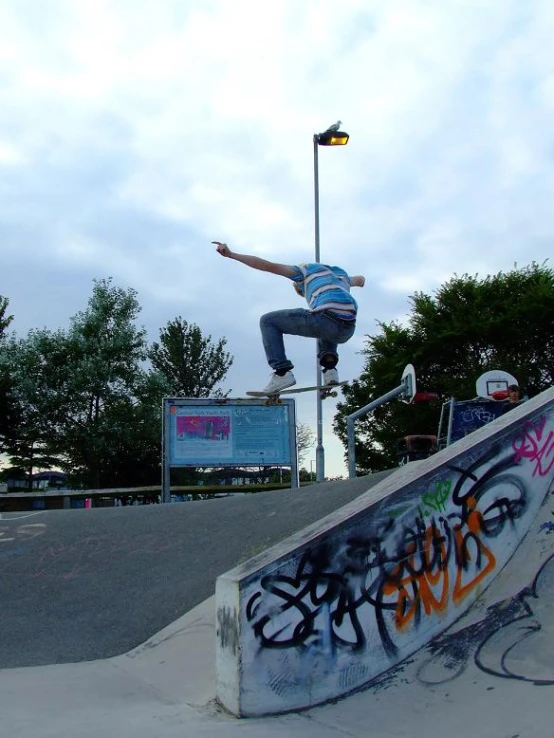man on skateboard in air at an outdoor skate park