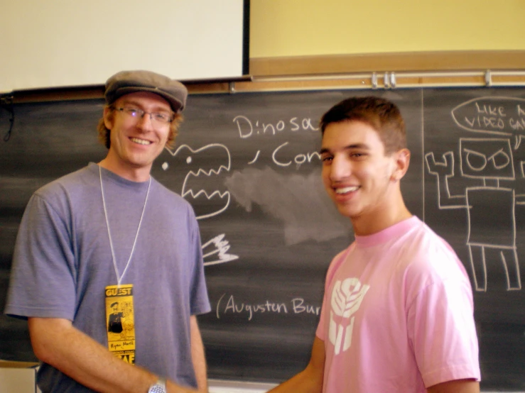 two men in a classroom shaking hands with one another