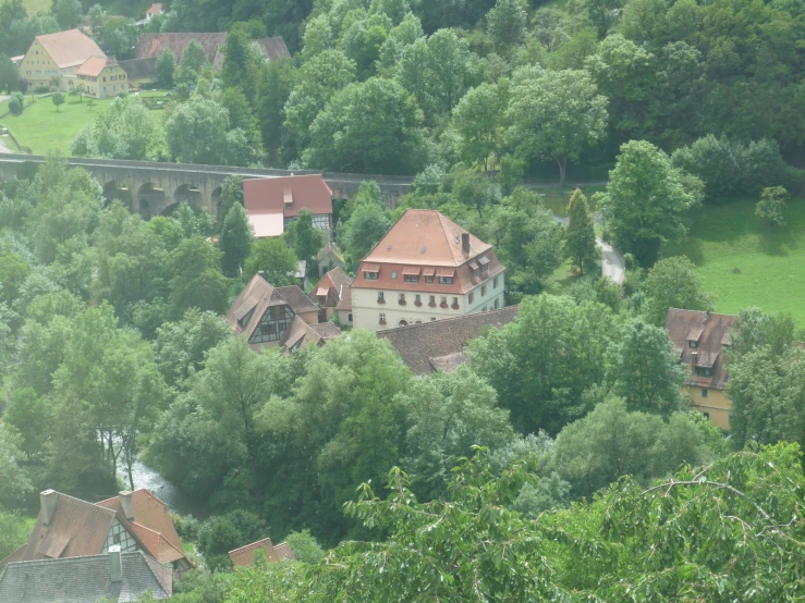 a large building nestled among some trees on a hill