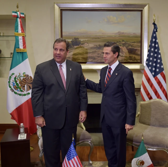 two people shaking hands in front of flags