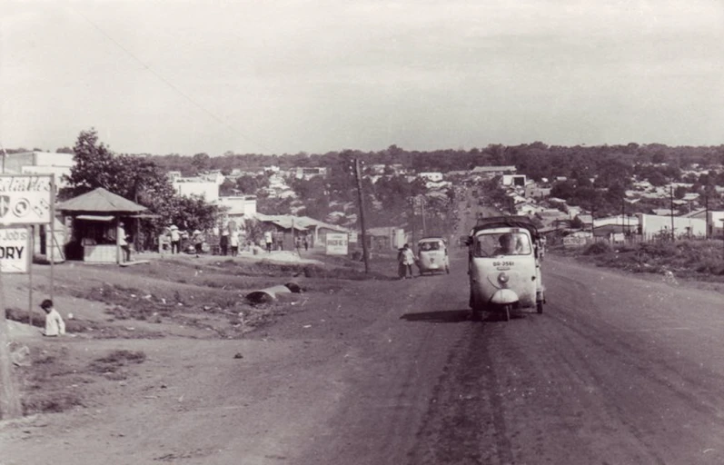 black and white image of an old time truck on dirt road