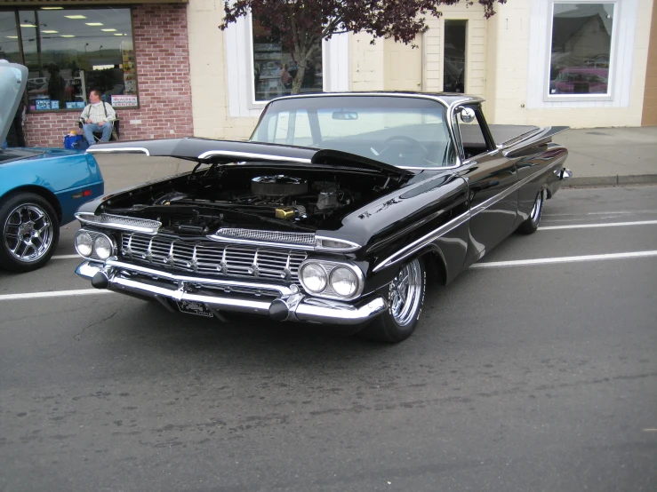 an old black car has its hood up