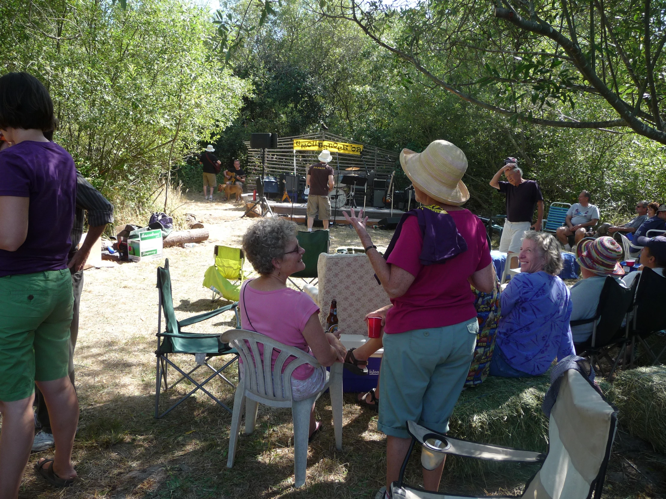 a group of people are gathered in the shade