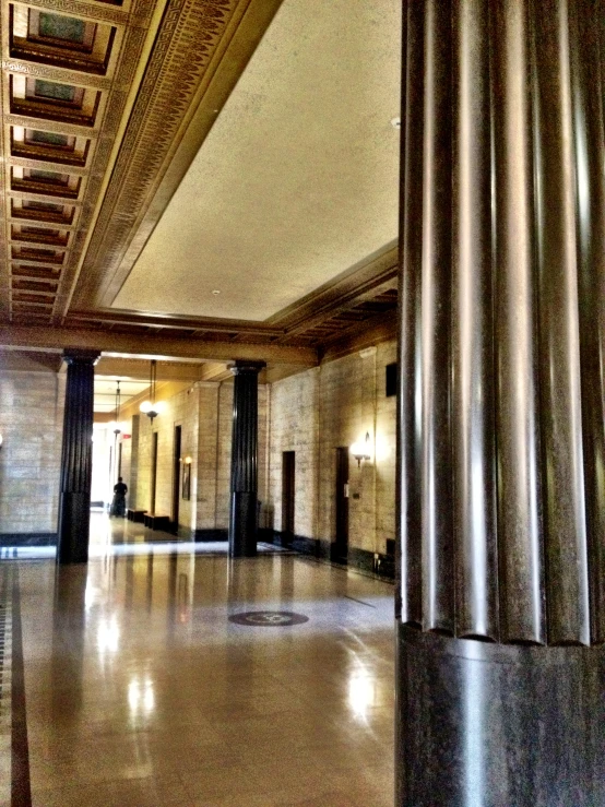 a very large empty building with columns, a ceiling and lights