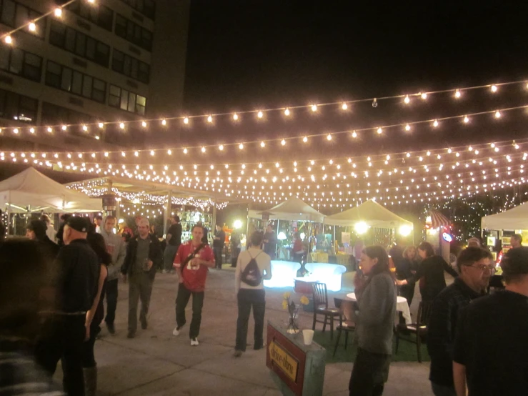 a crowd of people that are walking through a market