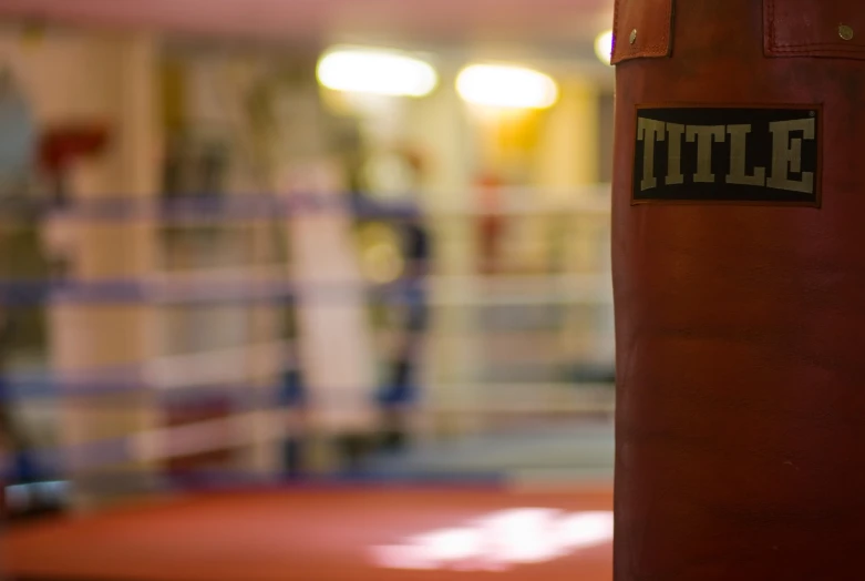 a red boxing bag is in the corner of a gym