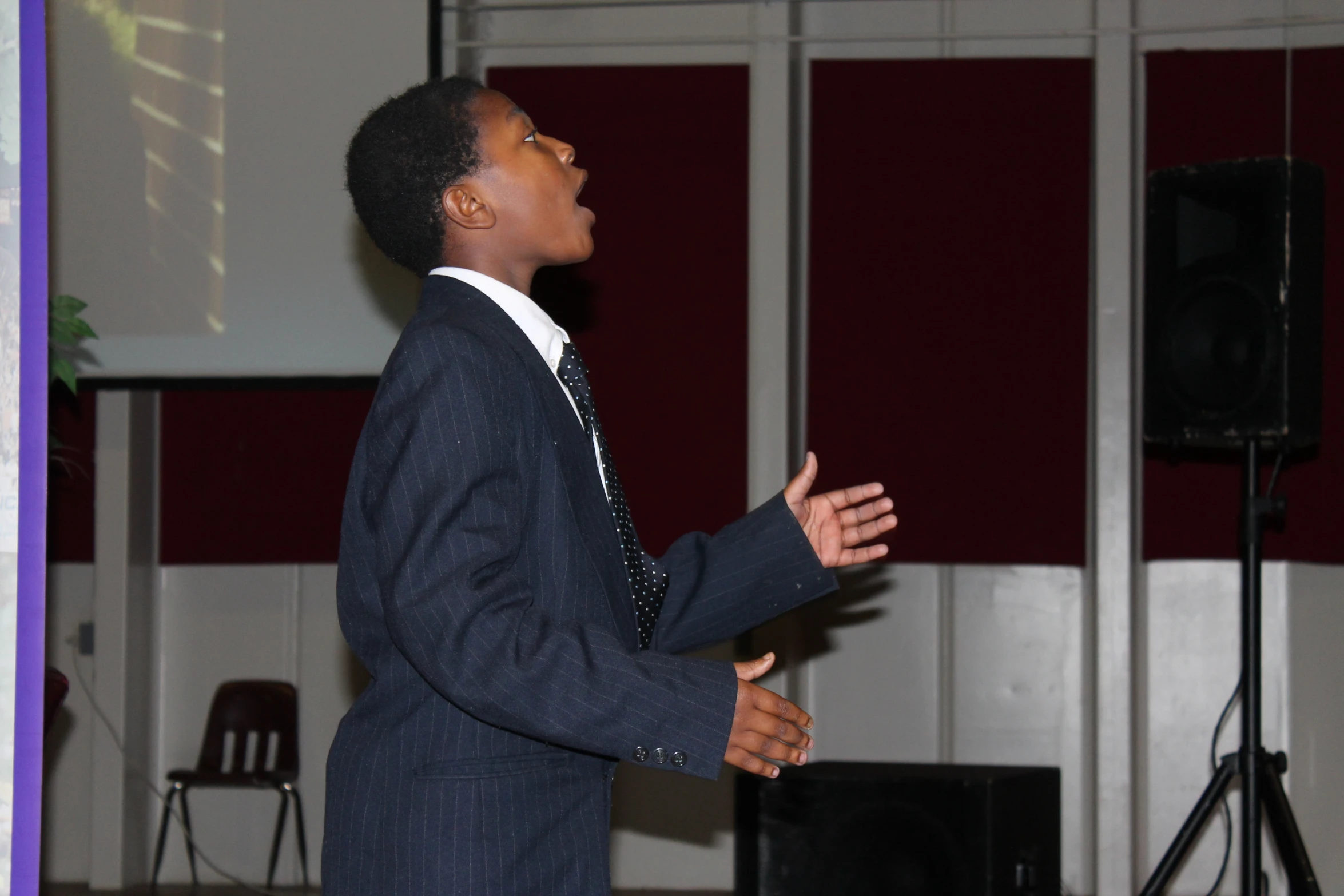 a man in a suit is speaking and gesturing