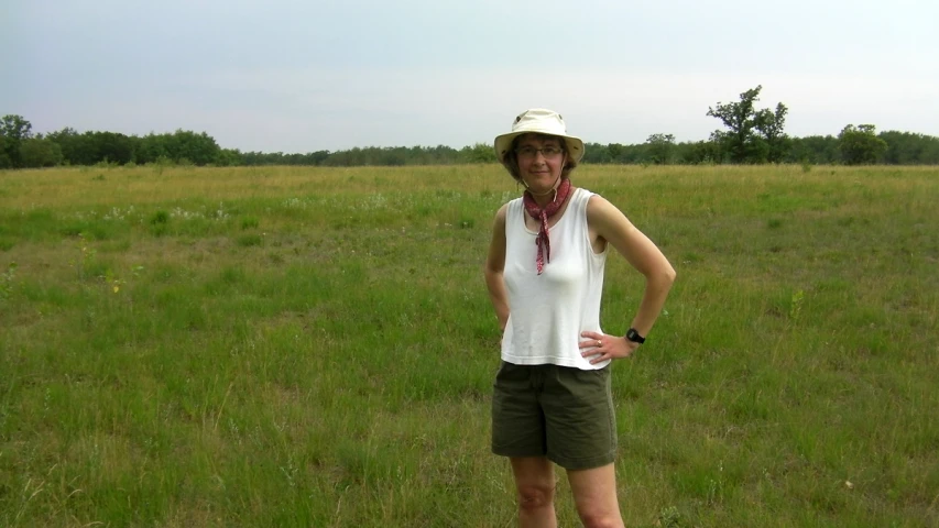 a lady in a field wearing shorts and a top