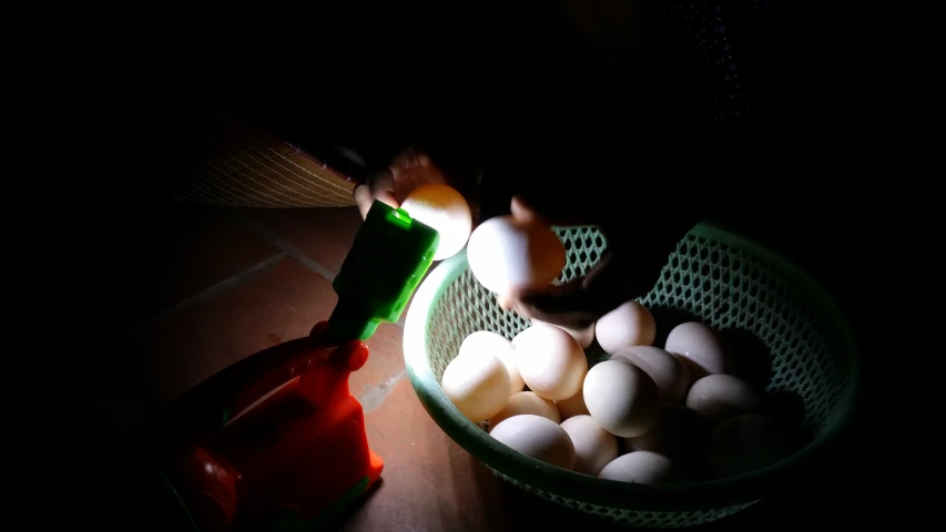 there are several eggs in the basket and one on the ground