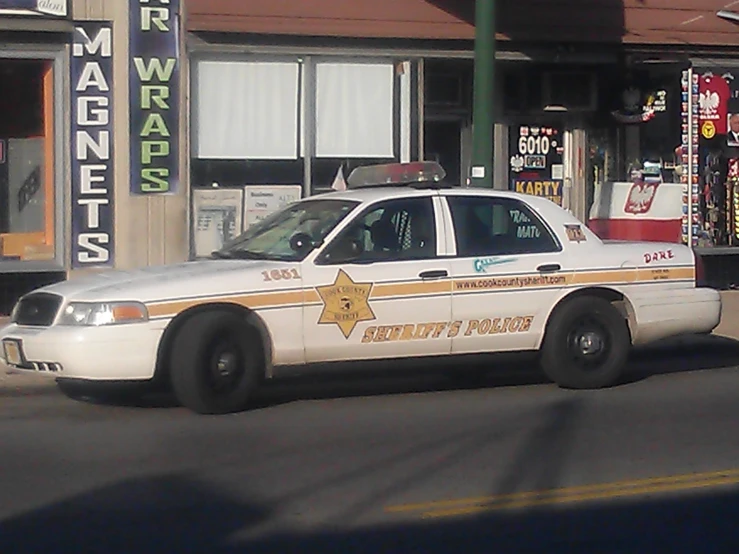 there is a police car parked in front of stores