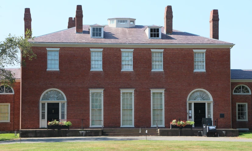 a brick building has windows and a black door