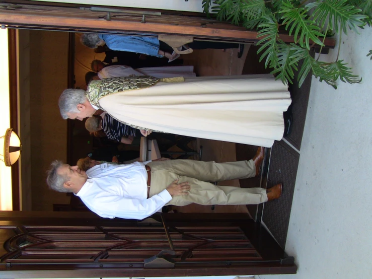 a man in a white coat and a woman in a beige dress