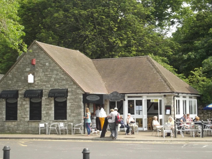 people sit outside an open house style restaurant