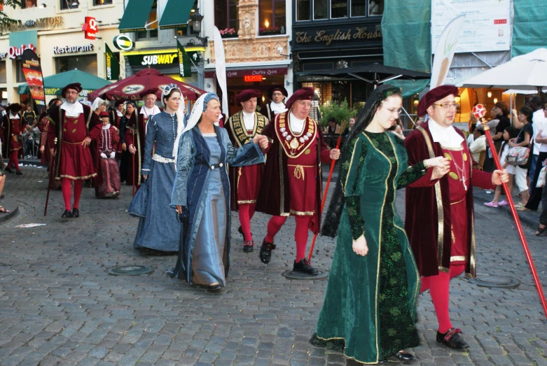 some people dressed in fancy dress walking down a street