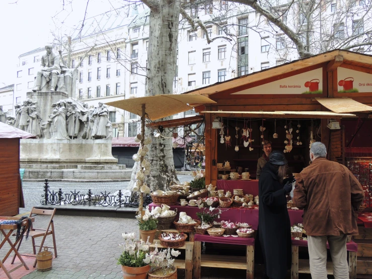 people standing around in front of small fruit stand