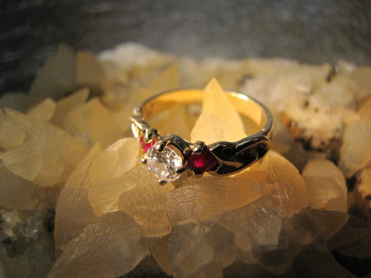 a yellow gold ring with two diamonds and a ruby