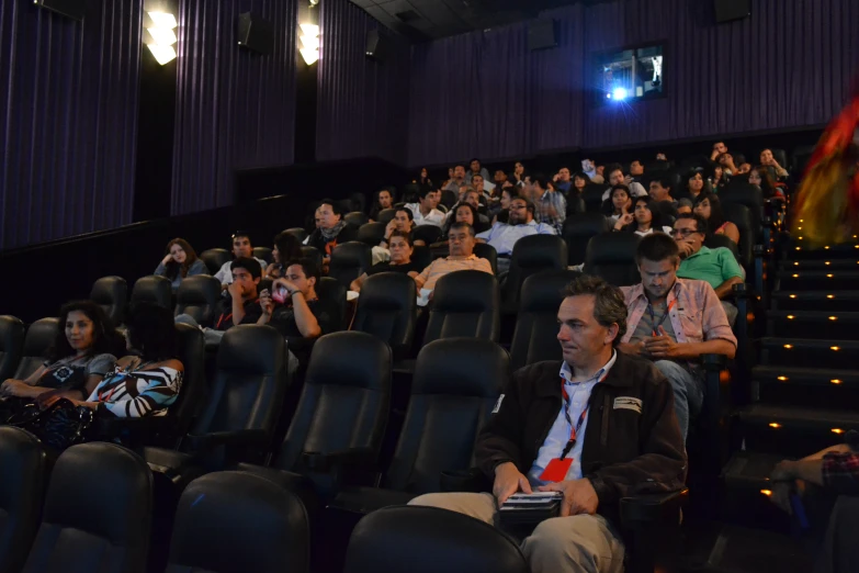 a group of people are sitting in the auditorium