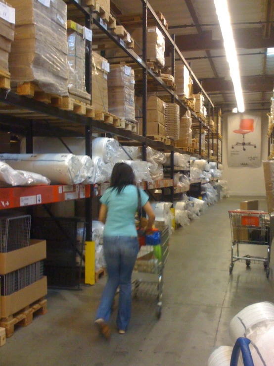 a woman hing a cart with bags in a warehouse