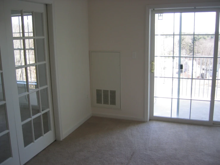 a white room with some glass doors near a window