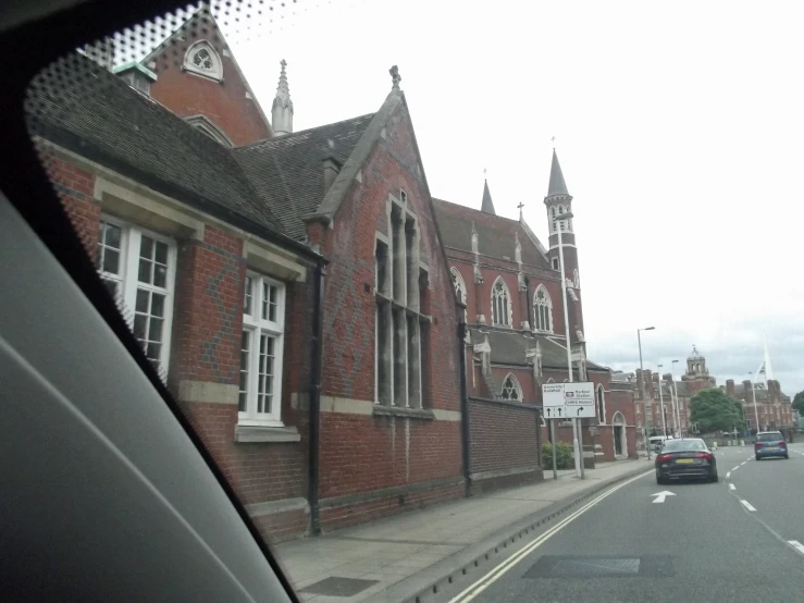 the car is driving beside a big building